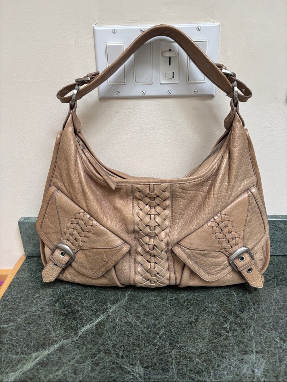 Junior Drake leather handbags with signature braided and buckled details.